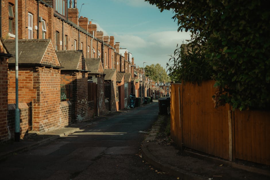 A panoramic view of a densely populated urban area with a mix of residential houses and high-rise commercial buildings in the background. In the foreground, there are traditional brick houses with red